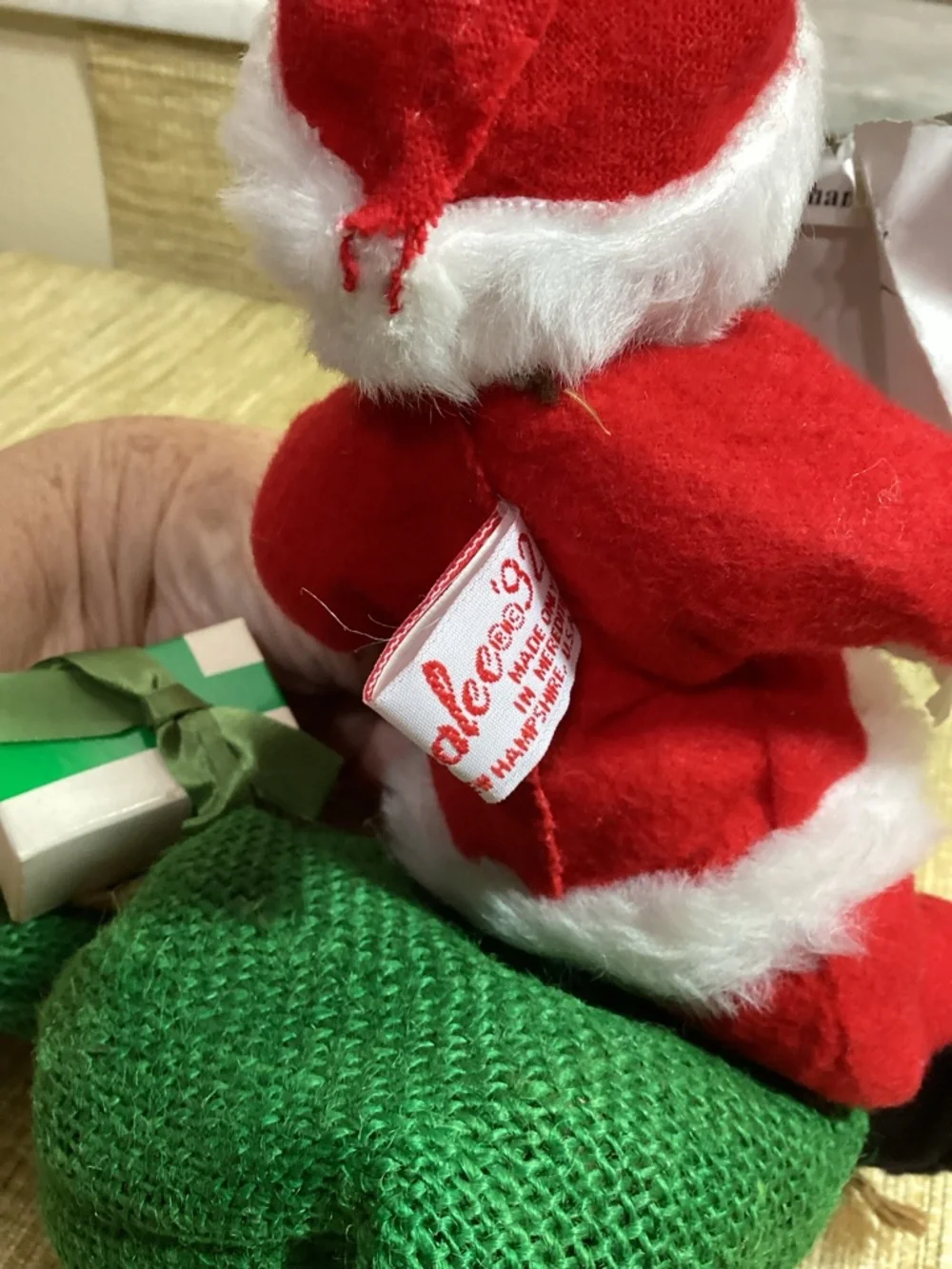 Vintage Anna Lee Red Santa Doll with White Trim sitting of his sack of toys